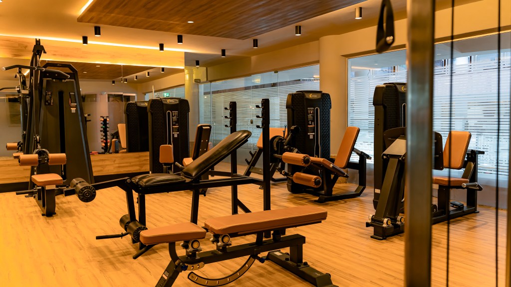 Banco para supino, supino peso livre e máquinas para treinos de perna na academia do Esmeralda.