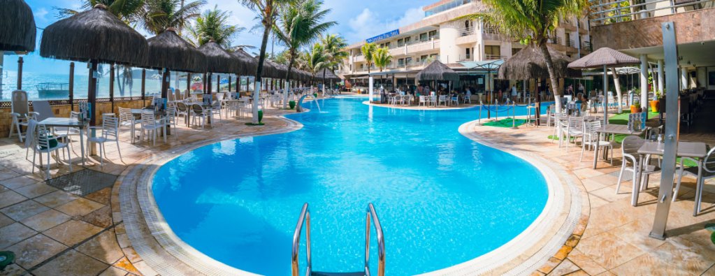 Visão ampla da área da piscina do Esmeralda Praia Hotel.