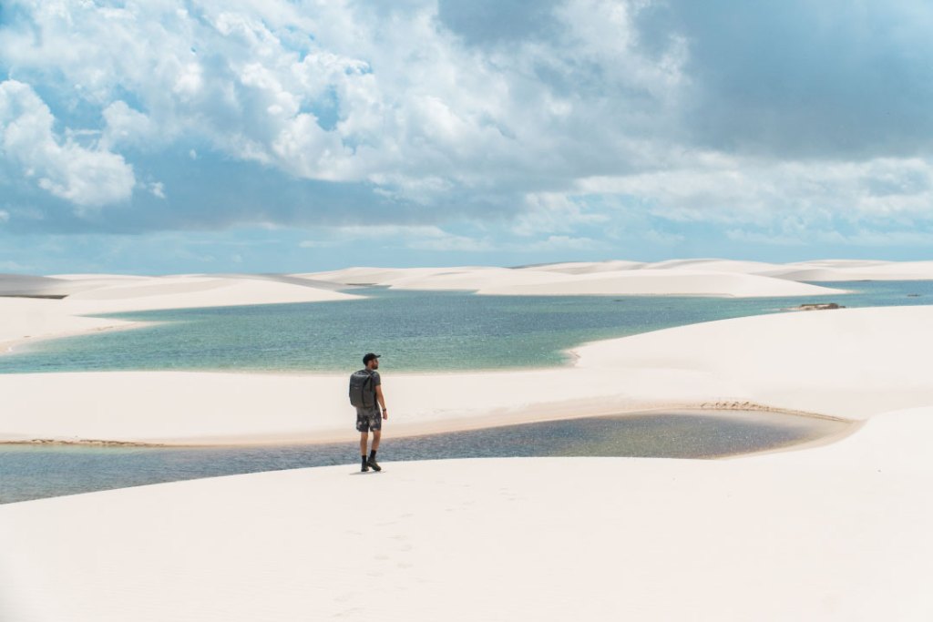 Homem passeando sobre as dunas nos Lençóis Maranhenses.