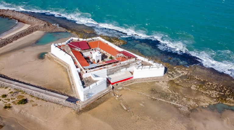 Natal, Rio Grande do Norte, Brazil - March 12 2021: Aerial view of Forte dos Reis Magos (Fort) and skyline of Natal city on background
