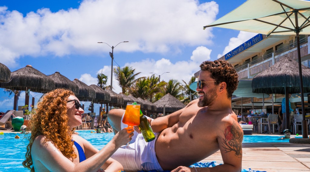 Casal aproveitando na beira da piscina no Esmeralda Praia Hotel, em Natal-RN.