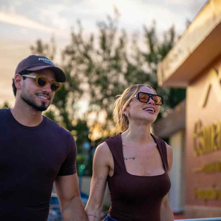 Hóspedes felizes chegando ao Esmeralda Praia Hotel durante o pôr do sol, hospedagem à beira-mar em Natal RN