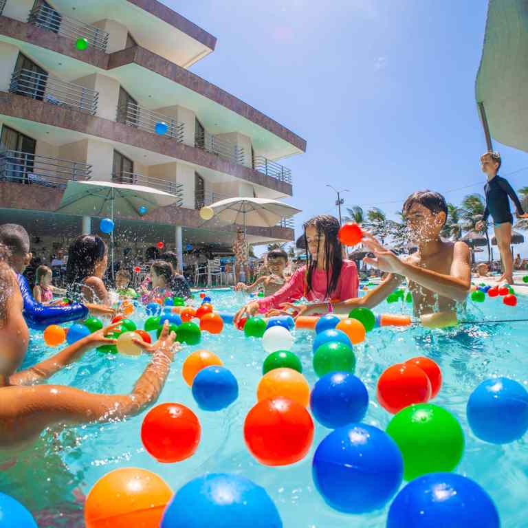 Piscina infantil do Esmeralda Praia Hotel em Natal Rio Grande do Norte com crianças se divertindo em atividade recreativa com bolas coloridas