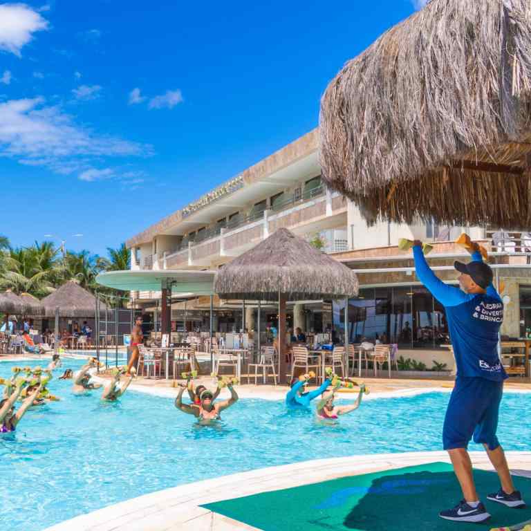 Turistas participando de uma animada aula de hidroginástica na piscina do Esmeralda Praia Hotel em Natal Rio Grande do Norte com instrutor conduzindo as atividades