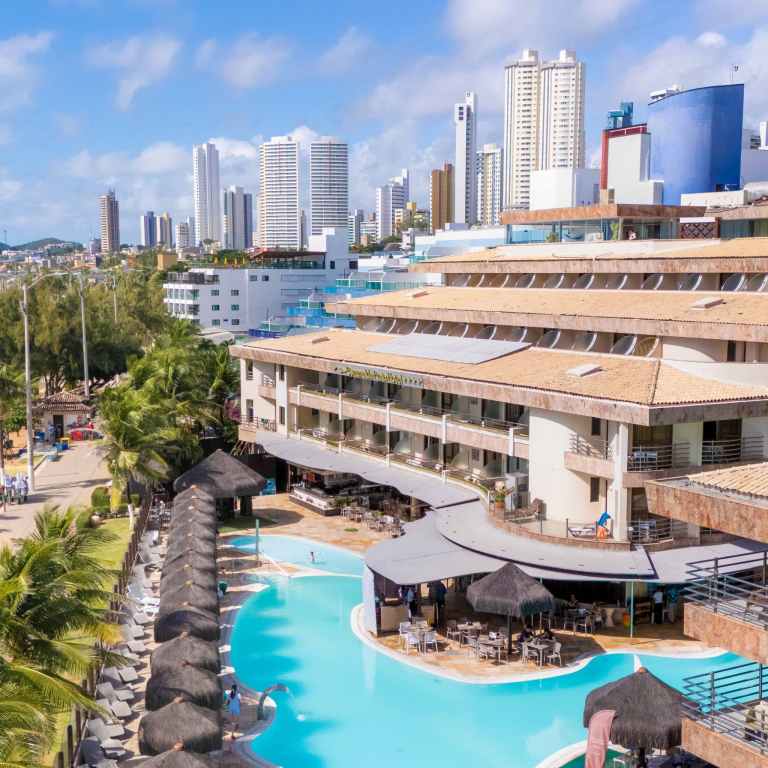 Vista aérea destaca a piscina do Esmeralda Praia Hotel em Ponta Negra com o skyline urbano de Natal Rio Grande do Norte ao fundo