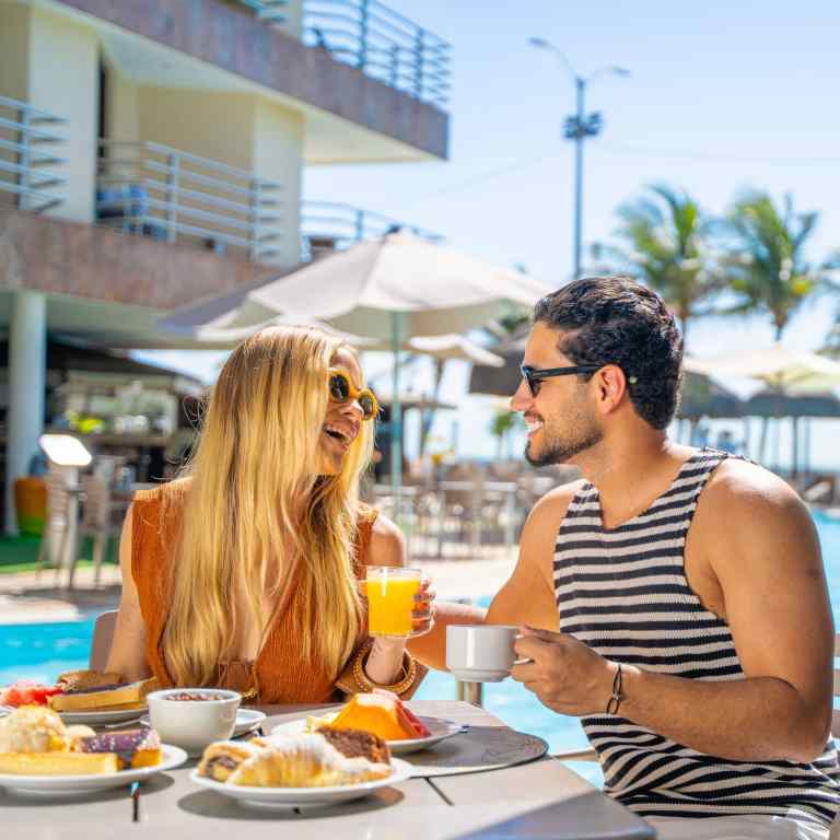 Hospedes-desfrutando-cafe-da-manha-tropical-com-frutas-e-quitutes-regionais-a-beira-da-piscina-de-resort-em-Natal-RN.jpg