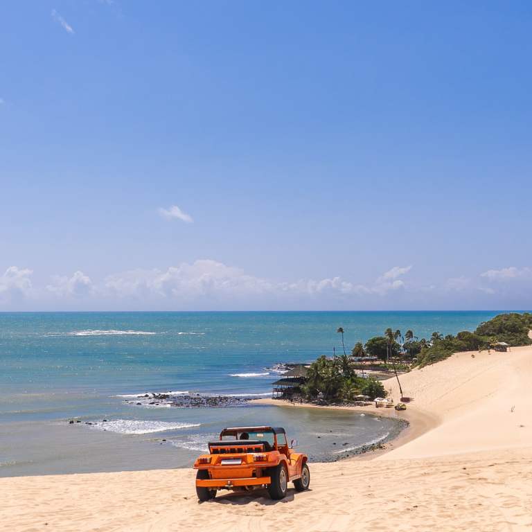 Passeio-de-buggy-laranja-pelas-dunas-de-Genipabu-com-paisagem-panoramica-do-litoral-paradisiaco-de-Natal-RN.jpg