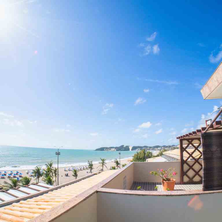 Sacada-ensolarada-no-Esmeralda-Praia-Hotel-em-Natal-Rio-Grande-do-Norte-com-plantas-decorativas-e-vista-panoramica-da-Praia-de-Ponta-Negra-e-do-famoso-Morro-do-Careca.jpg