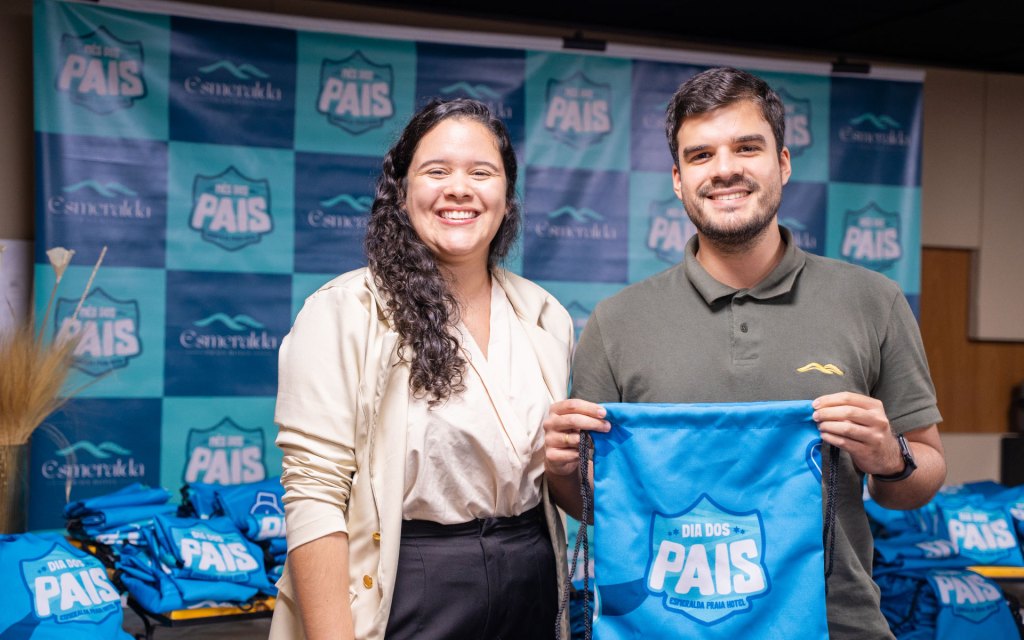 Colaboradores do Esmeralda Praia Hotel sorrindo com a mochila personalizada da campanha Dia dos Pais
