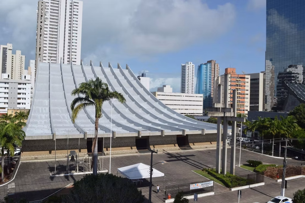 Catedral Metropolitana de Natal, com fachada em formato ondulado e prédios do centro da cidade ao fundo